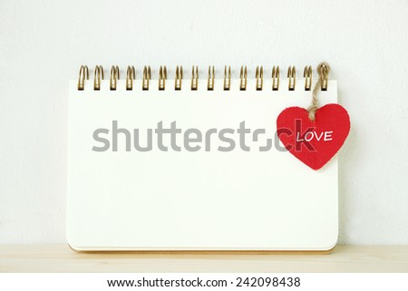 Blank note book with red heart on table, valentine's day concept background