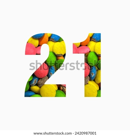 Number twenty one of colourful candies and paper cut in shape of twenty first digit isolated on white. Rainbow typeface