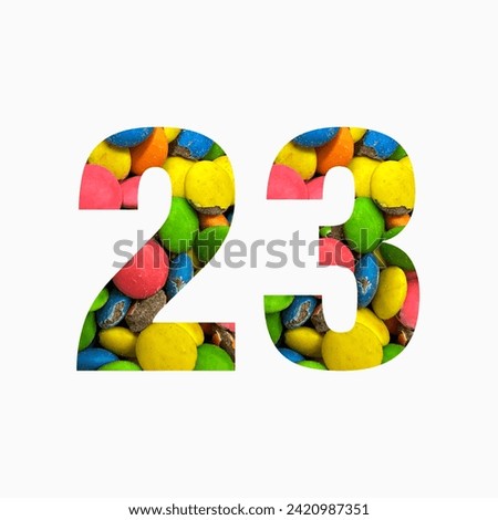 Number twenty three of colourful candies and paper cut in shape of twenty third digit isolated on white. Rainbow typeface