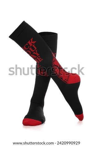 Close-up photo of women's printed compression socks. Pair of a black-red compression stockings for varicose veins are isolated on a white background. Front view.