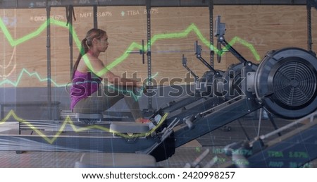 Image of data on graph over biracial woman training on rowing machine at gym. Fitness, exercise, strength, data, digital interface and technology digitally generated image.