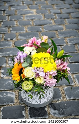 A vibrant bouquet of flowers sitting on a stone floor, offering abundant beauty amidst a serene setting.