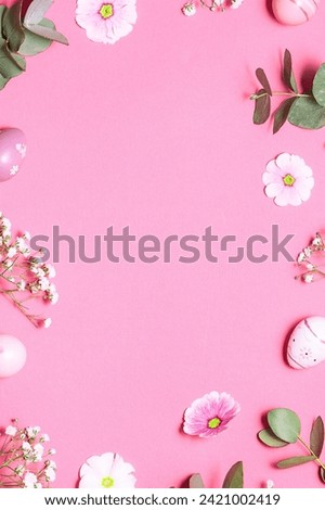 Bright frame made with fresh flowers, eucalyptus twigs and decorative eggs on light pink background with copy space for your design, vertical image. Happy Easter greeting card. Mother Day Concept.