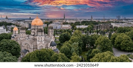 The Nativity of Christ Cathedral in Riga, Latvia. Byzantine-styled Orthodox cathedral, the largest in the Baltic region, with golden colored dome, polished gilded cupolas gleaming through the trees Royalty-Free Stock Photo #2421010649