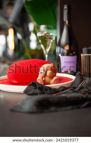 Heart Shaped Red Velvet Valentine's Day Cake with a bottle of sparkling wine and a glass in a restaurant. High quality photo