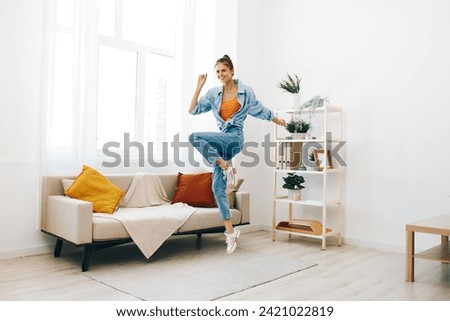 Joyful Woman Jumping and Dancing in a Playful Indoor Concept: Relaxation and Carefree Happiness
