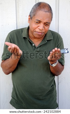 African american male expressions outside against a wall.