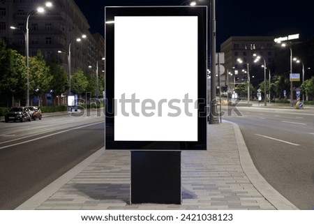Vertical billboard advertising in the night city. Between roads. Mock-up.