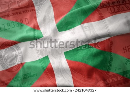 waving colorful national flag of basque country on a american dollar money background. finance concept.