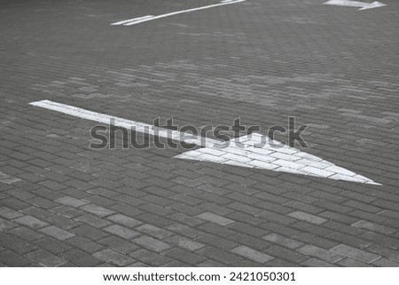 white arrow on gray asphalt, turn left, turn right, abstract white lines on asphalt, background of asphalt texture and white lines Royalty-Free Stock Photo #2421050301