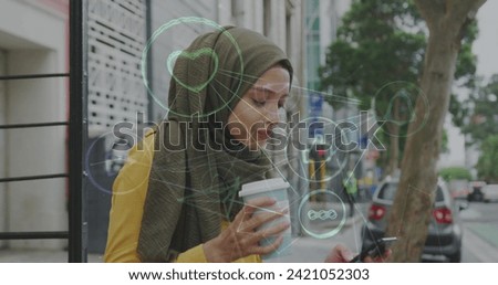 Image of connected social media icons with woman wearing hijab drinking coffee in street. communication technology digital interface concept, digitally generated image.