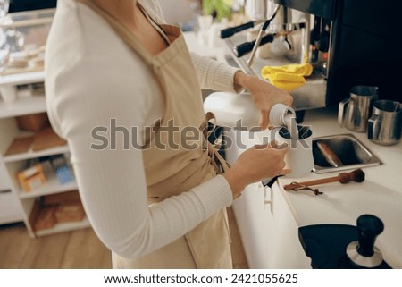 Close up of barista pouring milk into metal pitcher for making cappuccino . High quality photo