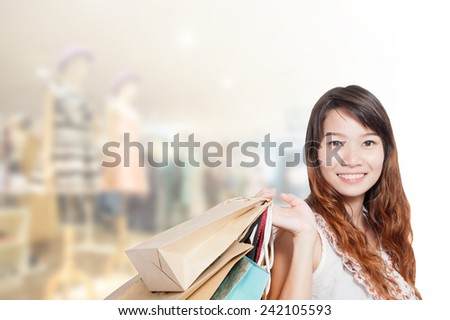 Asian businesswoman with long hair holding a sign board with a red hot sale has shopping mall background.black friday