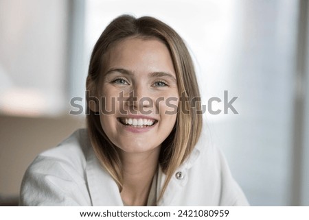 Beautiful young woman looking at camera having wide toothy smile advertises dental clinic services. Head shot portrait, profile picture of happy female spend time at home, photoshoot, staring at cam