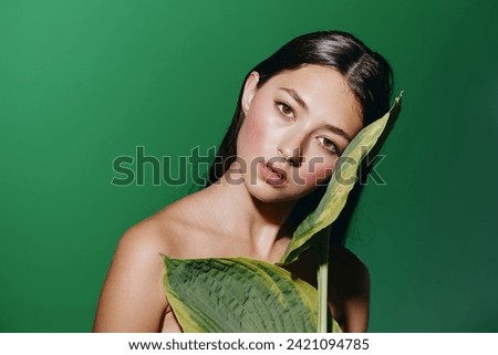 Green Summer Beauty: Young Caucasian Woman with Attractive Portrait and Fresh Makeup, Surrounded by Tropical Leaves in a Exotic Park Royalty-Free Stock Photo #2421094785