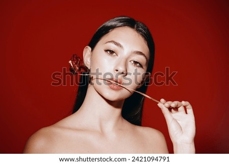 Beauty Women: Portrait of a Glamour Lady with Red Lipstick applying Makeup in a Fashionable White Background