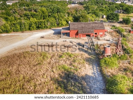 Aerial drone perspective of a rustic red barn at golden hour
