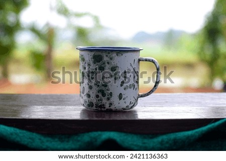 Vintage enamel mug with batik motif with blur background