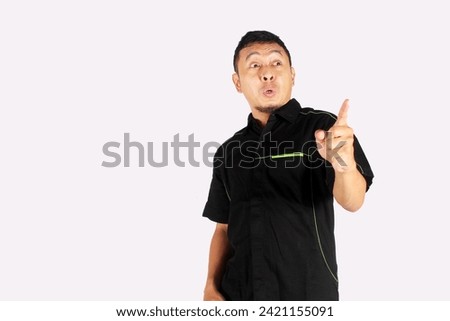 Asian adult man showing happy expression while pointing up
