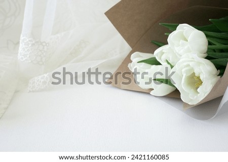 Bouquet of white tulips on a light background. Free space for text or inscription with greetings for Mother's Day, Spring Festival or Valentine's Day.                      