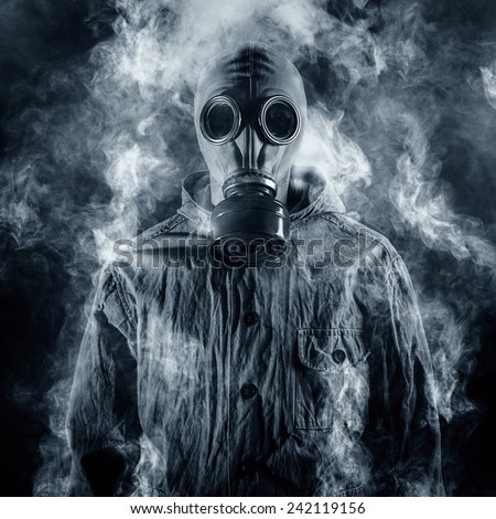 A man in a gas mask shrouded in smoke Royalty-Free Stock Photo #242119156