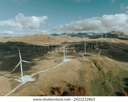 Renewable Future: Wind Turbines Amidst Autumn Hills Royalty-Free Stock Photo #2421212863