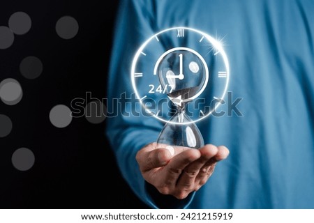 Nonstop service 24 hr concept. businessman hand holding hourglass 247 with clock on hand for worldwide nonstop and full-time available contact of service concept. customer service. Royalty-Free Stock Photo #2421215919