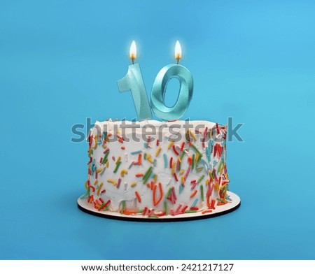 10 shaped candle light on happy birthday cake on blue