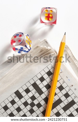 Newspaper, pencil and transparent dice on a white background Royalty-Free Stock Photo #2421230751