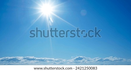 Clear Blue Sky Sun Sunlight Sun Rays and Glare and Cumulus White fluffy Clouds. blue sky with white cloud landscape background.
