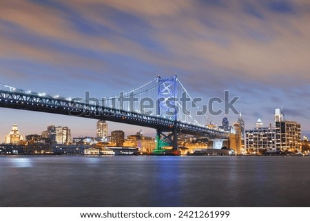 Philadelphia, Pennsylvania, USA skyline on the Delaware river with Ben Franklin Bridge at dusk.