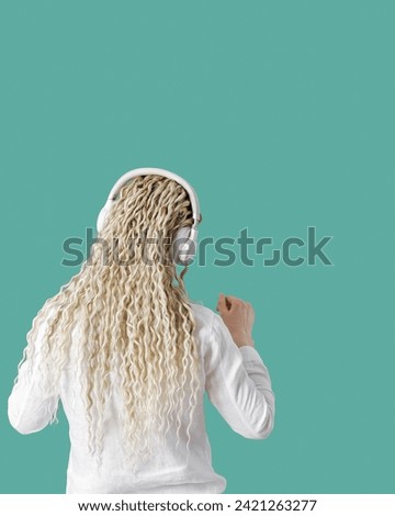 Modern stylish girl woman in headphones on head, listening to music and dancing, blonde long curly hair, back view, trend mint color background with copy space, minimal lifestyle no face portrait