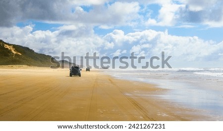 4WD trucks driving offroad on the Fraser island beach track near the SS Maheno shipwreck, half buried in the sand of the 75 mile beach on the east coast of the island in Queensland, Australia Royalty-Free Stock Photo #2421267231