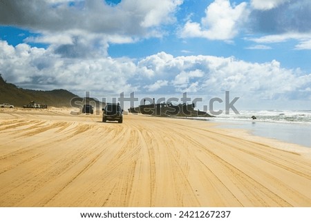 4WD trucks driving offroad on the Fraser island beach track near the SS Maheno shipwreck, half buried in the sand of the 75 mile beach on the east coast of the island in Queensland, Australia Royalty-Free Stock Photo #2421267237