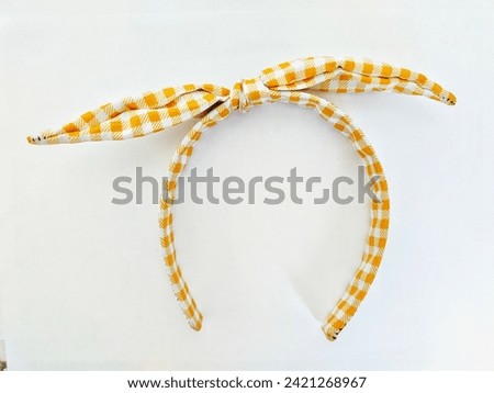 Women's headband with yellow and white dots motif on a white background
