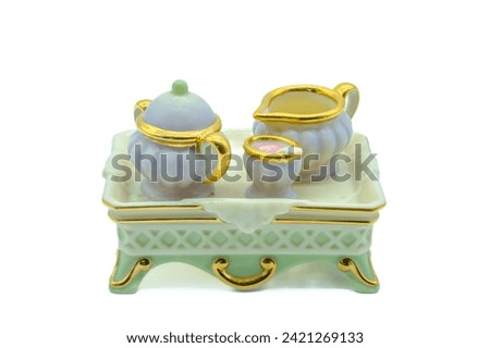 Antique miniature bone china tea set with tiny tea pot milk and sugar bowl on a serving tray also made from bone china or porcelain Royalty-Free Stock Photo #2421269133