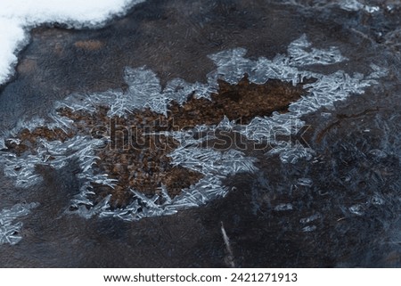 A thin pointed layer of ice on flowing water