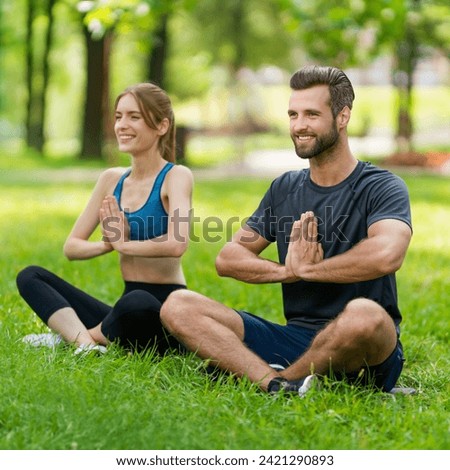 Full body young couple  sitting in lotus position or woman practicing with man, male bearded coach trainer, doing yoga exercises or meditating together, after outside training. Square image.