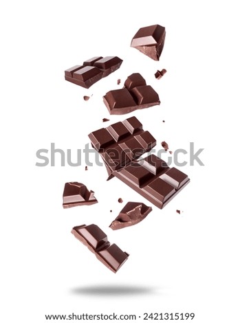 Broken bar of dark chocolate in the air isolated on a white background Royalty-Free Stock Photo #2421315199