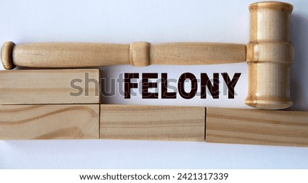 FELONY - word on the background of wooden blocks and a judge's gavel. Business concept Royalty-Free Stock Photo #2421317339