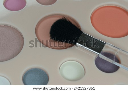 The make up brush is placed on the eye shadow palette. Close up. High quality photo