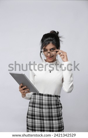 Naughty and cute Office secretary holding a tablet, wearing white top and a chequered skirt