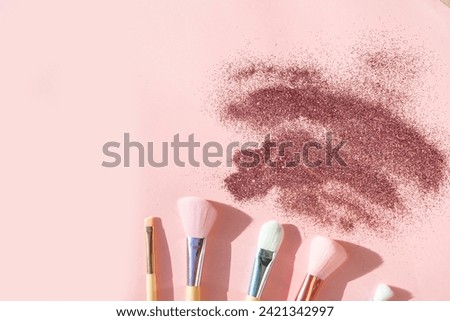 Minimal modern cosmetic scene with set of make up brushes set over pink background with glitter and shadow overlay