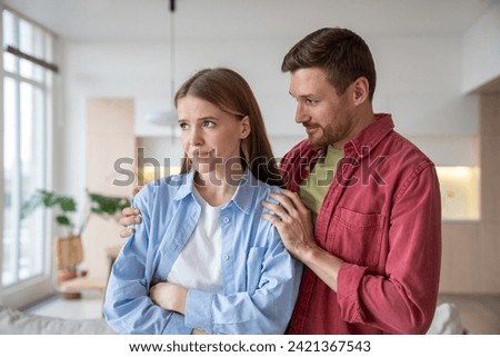Loving tender man supporting, calming down, embracing anxious upset troubled woman. Attentive husband showing empathy, compassion to beloved wife. Emotional support, harmony in family relations Royalty-Free Stock Photo #2421367543