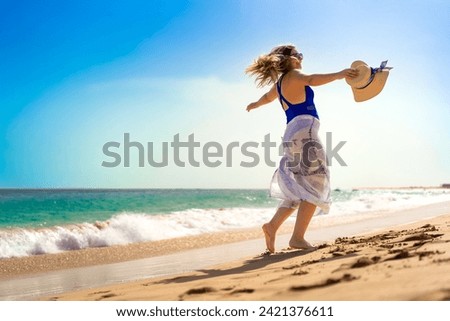 Beautiful woman walking on sunny beach Santa Maria, Sal Island, Cape Verde  Royalty-Free Stock Photo #2421376611