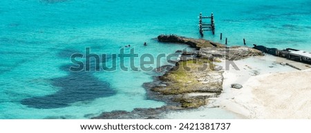 Aerial view of sandy beach, remains of old pier and ocean with small waves in Cancun, Mexico. Playa Caracol of Riviera Maya in Quintana roo region on the Yucatan Peninsula