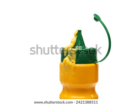 Close-up of mustard runs down a plastic bottle. Isolated against white background.
