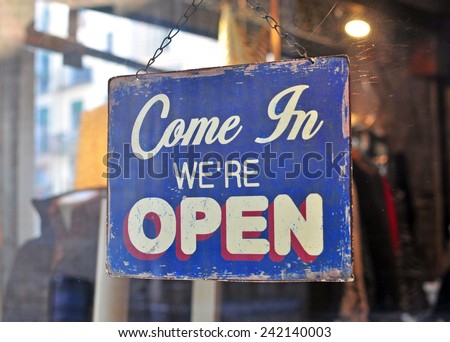 Nostalgic Invitation: A Hanging Vintage 'Open' Sign in a Welcoming Shade of Blue