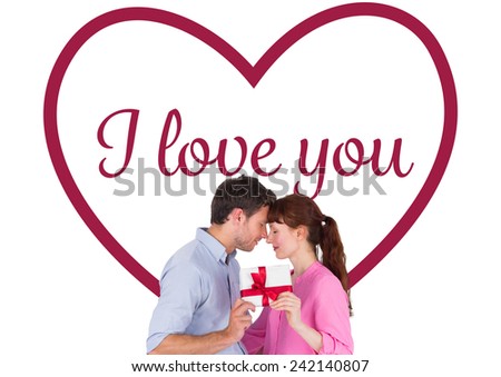 Loving couple holding a gift against valentines love hearts