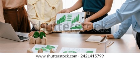Professional business team presenting green business project by using graph to explain benefit of using renewable energy at modern meeting room. Closeup. Focus on hand. Delineation.